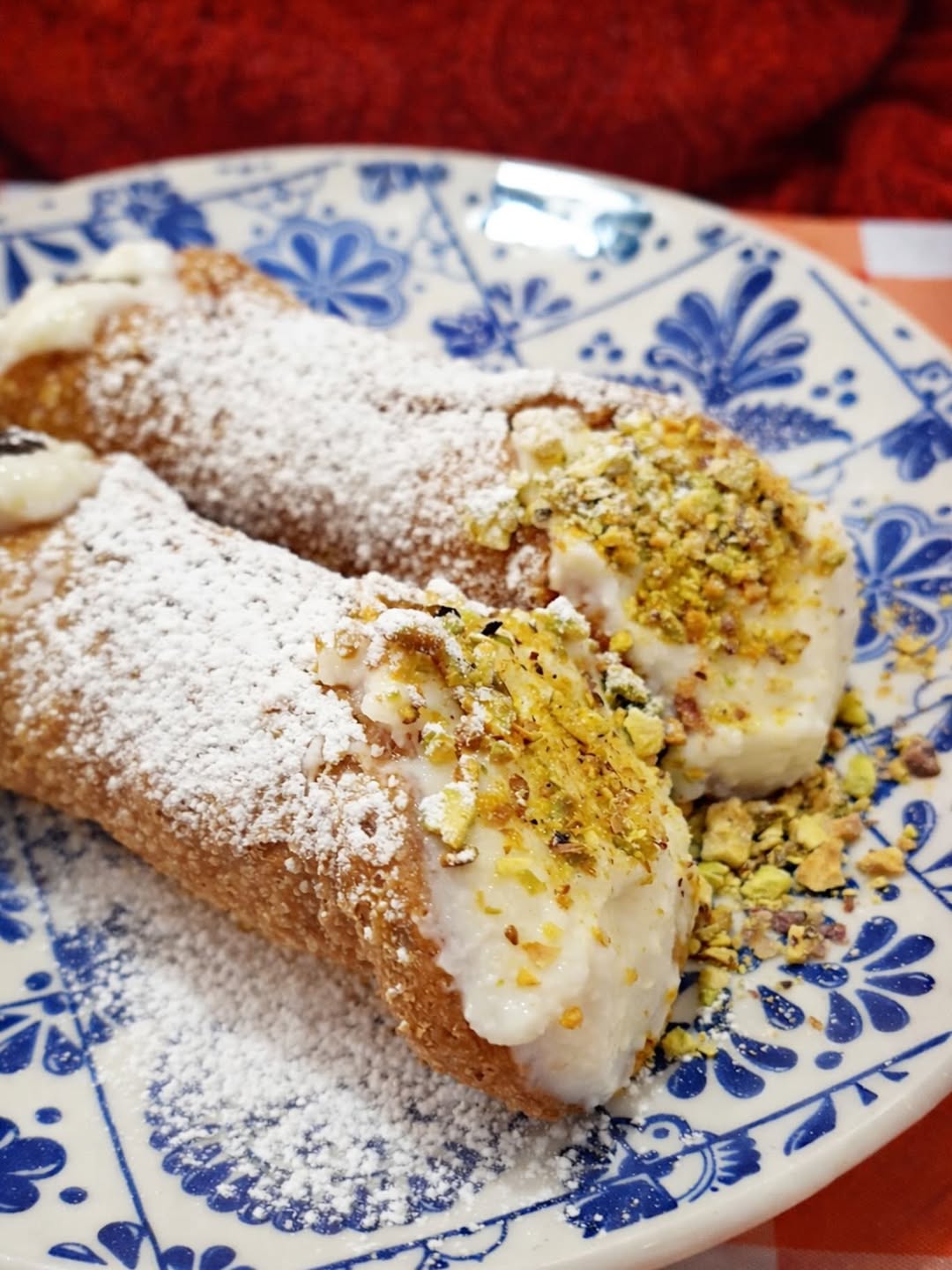 Cannoli com pistácio sobre prato azul